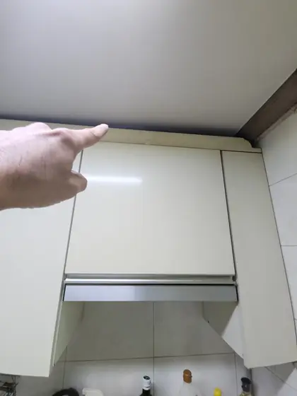 주방 상부장 수리 — 손가락으로 가리킨 벌어진 틈