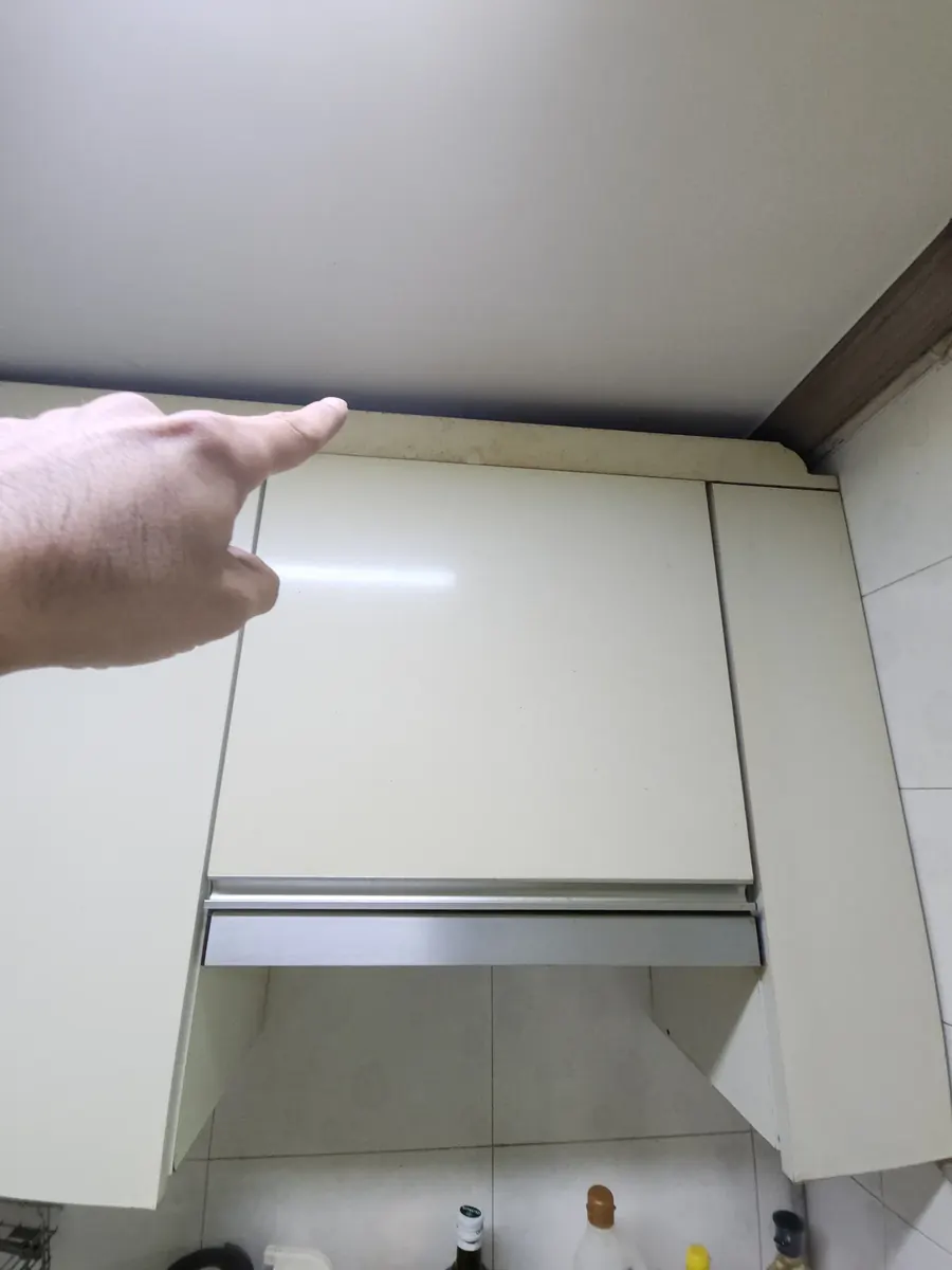 주방 상부장 수리 — 손가락으로 가리킨 벌어진 틈